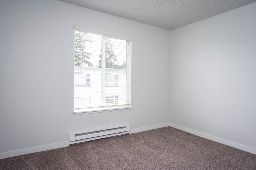 an empty room with white walls and a window
